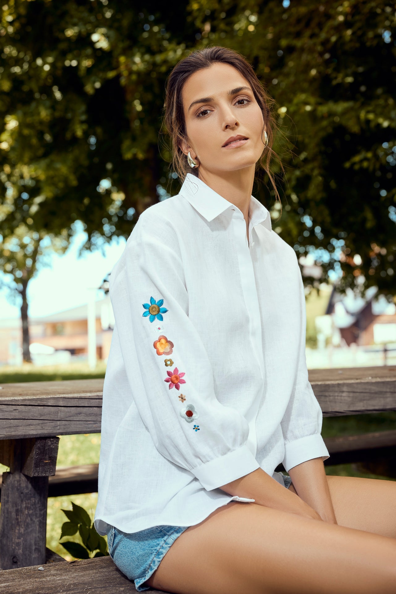 Bluse in weiß aus Leinen mit überschnittener Schulter, 3/4 Arm gezügelt in kurzer Manschette mit Floraler Stickerei an Arm, Wallmann Sommerkollektion