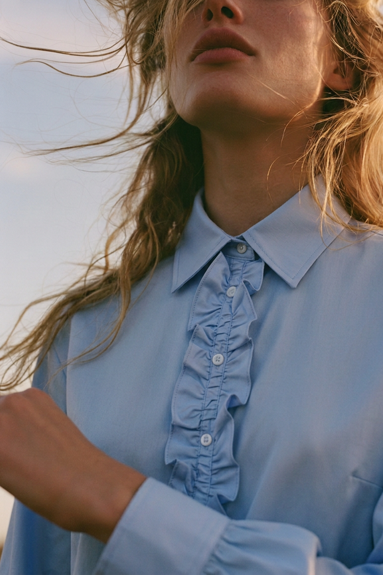 Bluse in blau mit Rüschenbesatz an der Knopfleiste